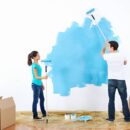 Kobieta i mężczyzna podczas malowania ścian w domu