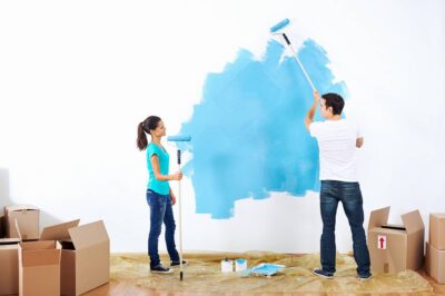 Kobieta i mężczyzna podczas malowania ścian w domu